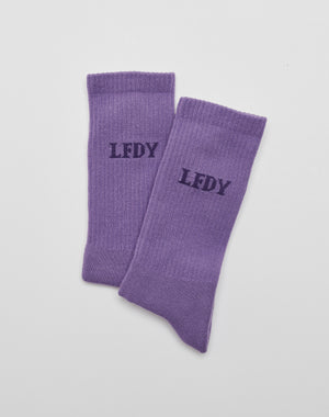 A pair of LIVE FAST DIE YOUNG LFDY Logo Socks (2 Pack) in purple, crafted from soft Baumwolle, featuring black LFDY logo print on top, displayed flat on a white surface.