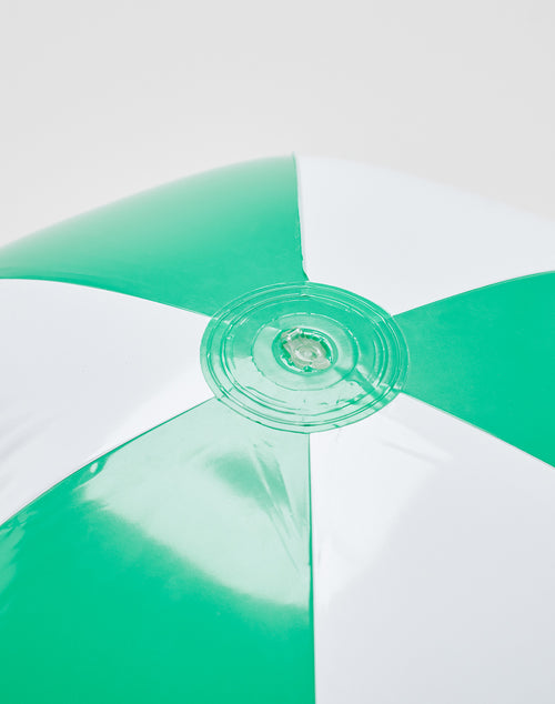 Close-up of the LFDY Beach Ball by LIVE FAST DIE YOUNG, featuring green and white alternating panels and a central air valve. The background is plain and light-colored.