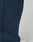 Close-up of a person wearing LIVE FAST DIE YOUNG's LFDY Active Fleece Jogger, dark blue wide fit pants with a visible seam and small fabric tag. A white sneaker is partially visible on a light surface.