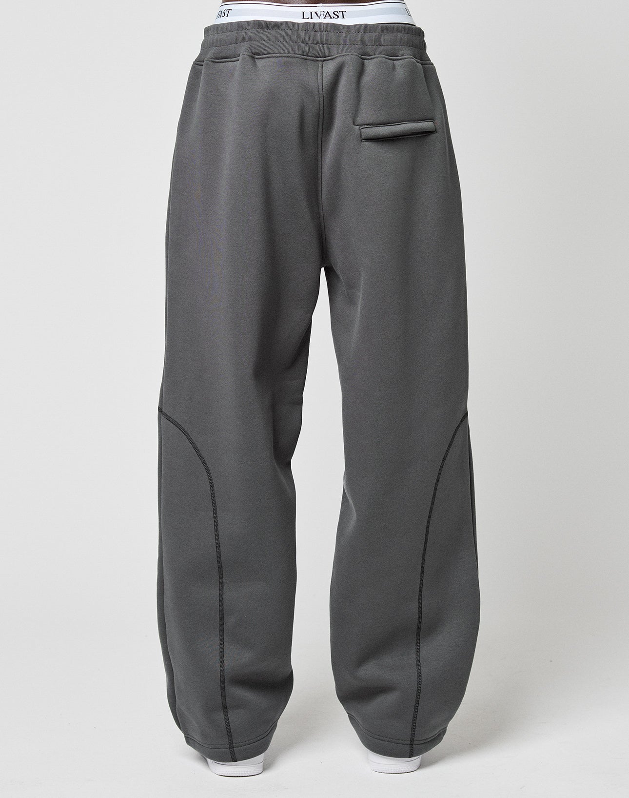 The LFDY Active Fleece Jogger by LIVE FAST DIE YOUNG features a wide fit, visible seam details, flatlock-topstitching, a small front flap pocket, and exposed white waistband elastic, shown against a plain light background.