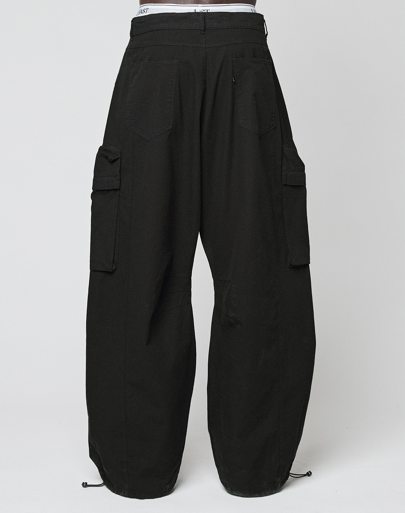 The LFDY Baggy Cargo by LIVE FAST DIE YOUNG features a relaxed baggy fit, black color, large cargo pockets, visible white waistband, and adjustable cuff drawstrings, shown against a plain white background.