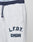 Close-up of the LFDY District Jogger by LIVE FAST DIE YOUNG: light gray, wide fit sweatpants with dark blue drawstrings, "L.F.D.Y." and "GMBH" stitched in bold dark blue on the left thigh, next to a zippered side pocket.