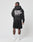 A person with braided hair wears the LIVE FAST DIE YOUNG Basic 360 Hooded in black with bold white text and black shorts. The oversized fit and contrast topstitching stand out. They pair it with white socks and sneakers against a plain backdrop.