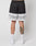 A person stands facing away in LIVE FAST DIE YOUNGs LFDY Racing Mesh Shorts, featuring black and white polyester mesh with LIVE FAST on the back. They wear white socks, white sneakers, and a colorful tattoo is visible on their left calf against a plain background.