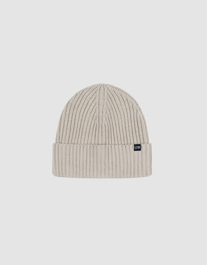 The LIVE FAST DIE YOUNG Washed Rib Knit Beanie is a light grey, one-size ribbed knit with a folded cuff and small black flag-label, made from soft polyamide, shown against a plain white background.
