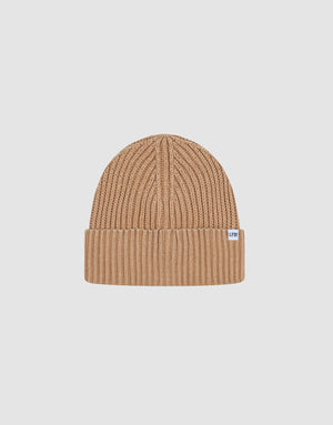Die Washed Rib Knit Beanie von LIVE FAST DIE YOUNG ist eine tanfarbene Mütze aus 100% Baumwolle mit Rippenstrick, gefaltetem Rand und kleinem weißen Seitentikett, präsentiert auf hellem, schlichten Hintergrund.