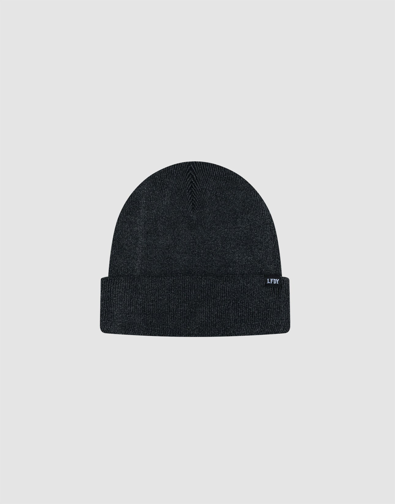 The LIVE FAST DIE YOUNG Basic Beanie is a plain, dark gray one-size beanie made from 100% Baumwolle. It features a folded brim, a visible Flaglabel tag on the edge, and is shown on a light gray background.