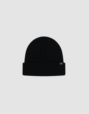 The LIVE FAST DIE YOUNG Basic Beanie is a soft black Baumwolle knit hat with a folded brim, one size fits all, and features a small rectangular flaglabel on the right side. Displayed against a light gray background.