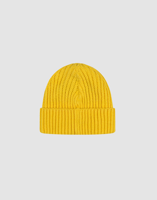 A yellow Rib Knit Beanie from LIVE FAST DIE YOUNG aus 100% Baumwolle mit gefaltetem Brim ist zentral auf einem schlichten, hellgrauen Hintergrund platziert.