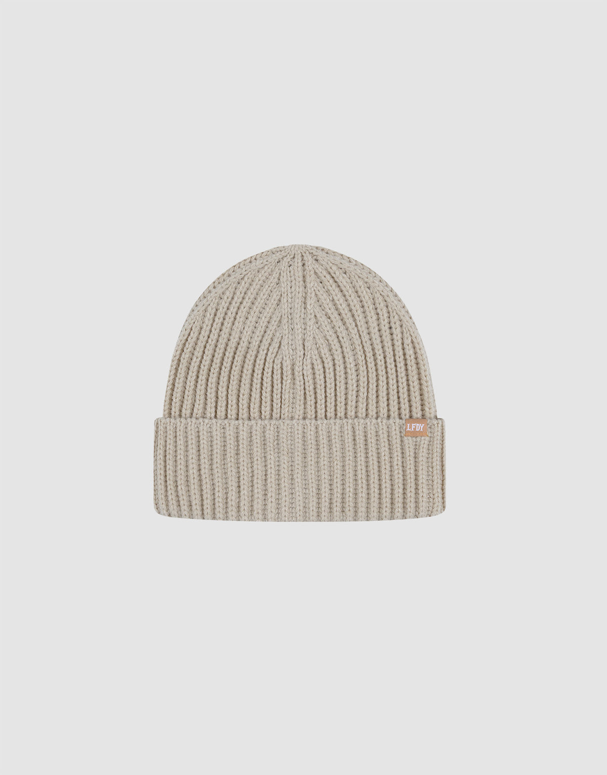 The LIVE FAST DIE YOUNG Rib Knit Beanie in beige is made from soft polyacryl, has a folded brim and a small rectangular side tag, and is shown against a plain white background. 