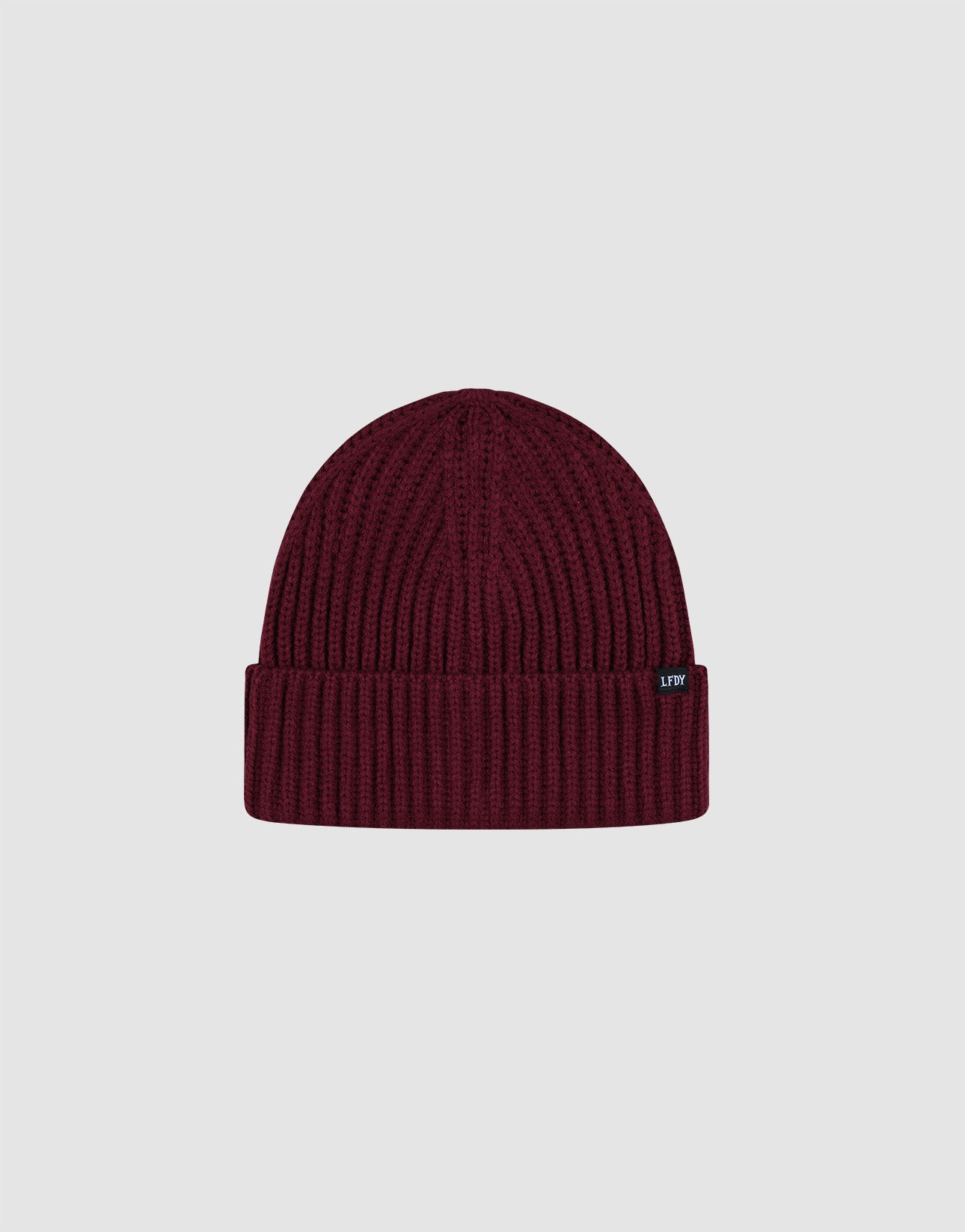 The LIVE FAST DIE YOUNG Rib Knit Beanie in maroon features a ribbed knit design, folded cuff, and small black Flag-Label tag on the cuff, shown against a plain light grey background.