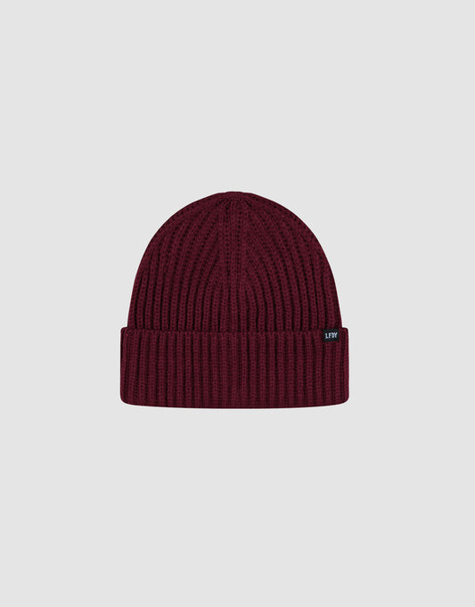 The LIVE FAST DIE YOUNG Rib Knit Beanie in maroon features a ribbed knit design, folded cuff, and small black Flag-Label tag on the cuff, shown against a plain light grey background.