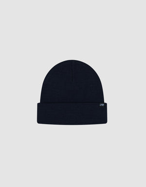 The LIVE FAST DIE YOUNG Basic Beanie is a plain, dark navy knit with a folded brim and a small rectangular flag-label featuring subtle text, shown against a light grey background.
