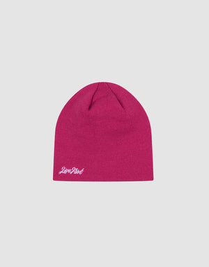 The LIVE FAST DIE YOUNG Script Beanie is a bright pink, one-size polyacryl hat featuring a small white Script Logo-Stick embroidered near the edge, shown on a light gray background.