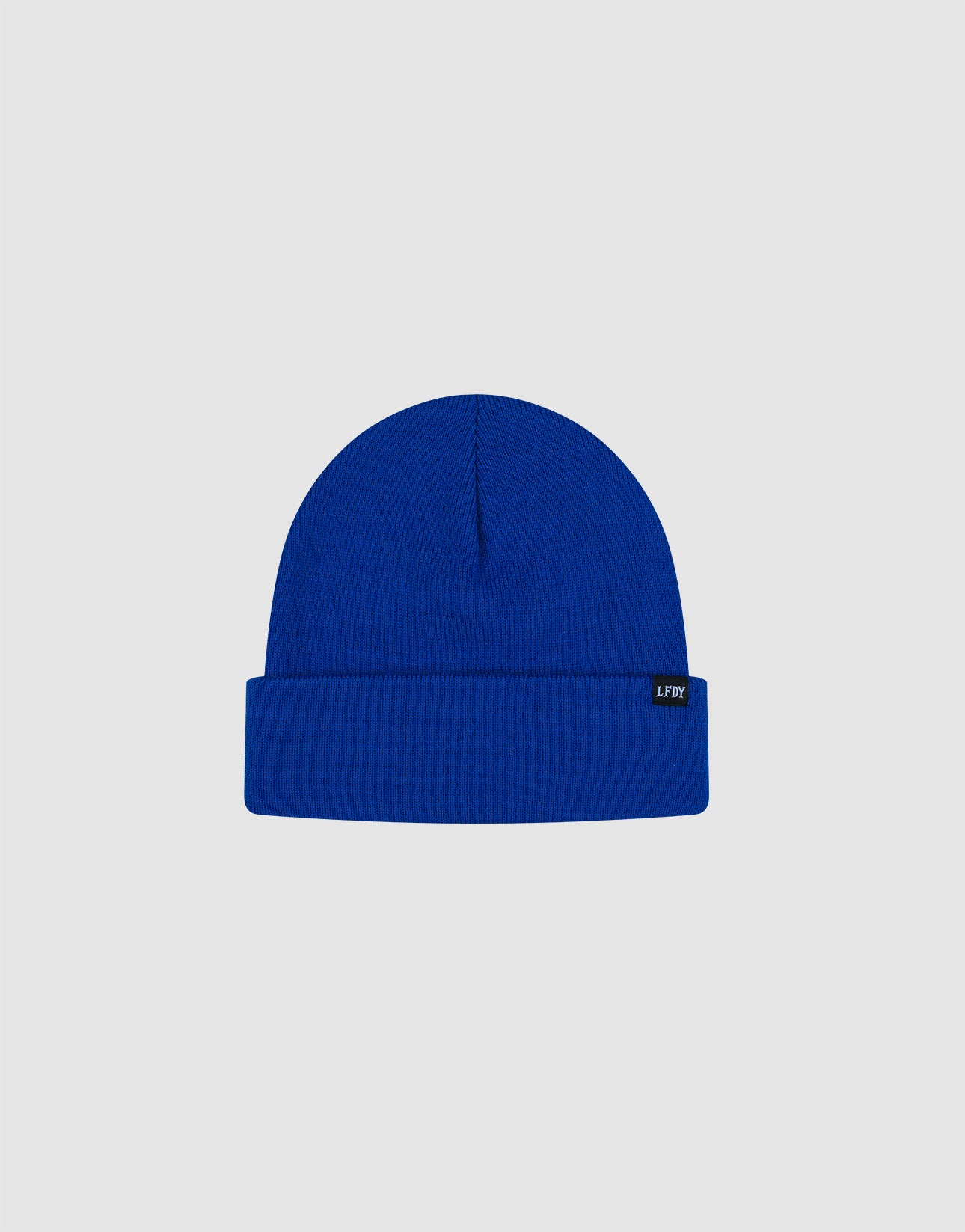 The LIVE FAST DIE YOUNG Basic Beanie is a bright blue, one size polyacryl knit with a folded brim and a black flaglabel with white text on the left side, shown on a plain light gray background.