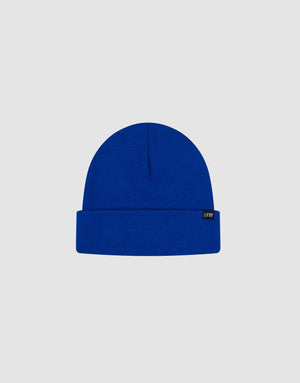 The LIVE FAST DIE YOUNG Basic Beanie is a bright blue, one size polyacryl knit with a folded brim and a black flaglabel with white text on the left side, shown on a plain light gray background.
