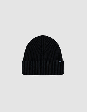 A black Washed Rib Knit Beanie by LIVE FAST DIE YOUNG, made from soft cotton with a ribbed knit and folded brim featuring a small rectangular label, is displayed against a plain light gray background.