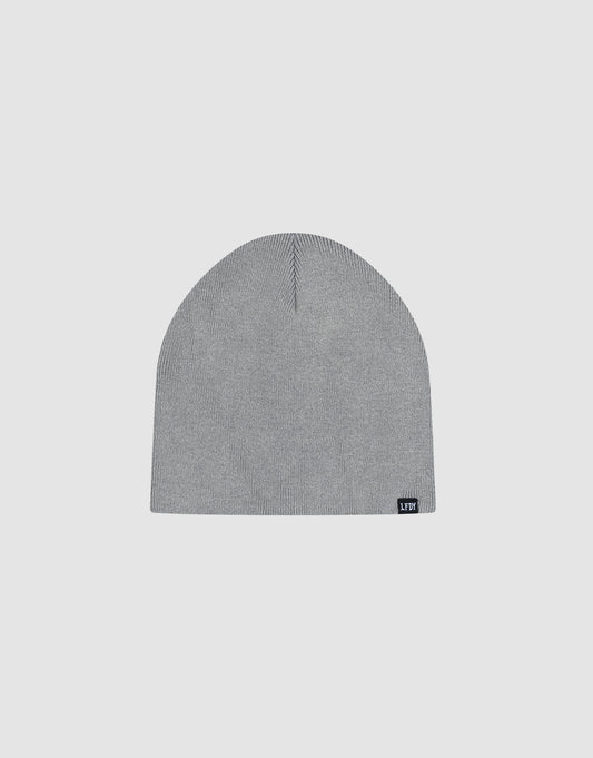 The LFDY Uncuffed Beanie is a plain light gray knit hat made from 100% Baumwolle, featuring a small black rectangular logo patch with white text on the lower edge, shown on a light gray background.