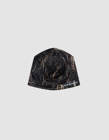 The Live Fast Performance Beanie by LIVE FAST DIE YOUNG features a camouflage pattern with brown and tan grass streaks, a soft Fleece Innenseite, and a partial white "Silver" logo print. Displayed on a plain light gray background.