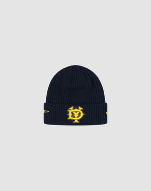 The LFDY x New Era Beanie by LIVE FAST DIE YOUNG features navy blue ribbed knit, a folded brim, yellow embroidered DY Logo with yellow designs, and stands out sharply against a light gray background.
