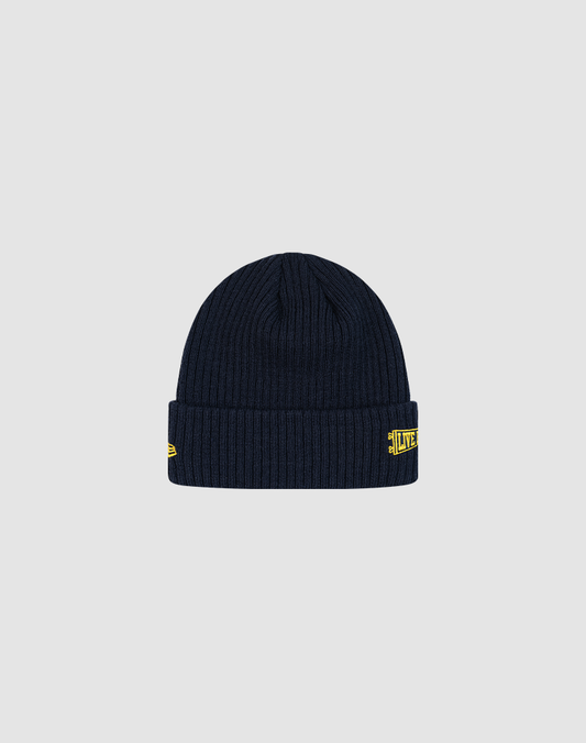 The LFDY x New Era Beanie by LIVE FAST DIE YOUNG is a ribbed dark navy knit hat with a folded cuff, small yellow embroidered patches, and DY logos on the front and left side, shown against a plain light grey background.