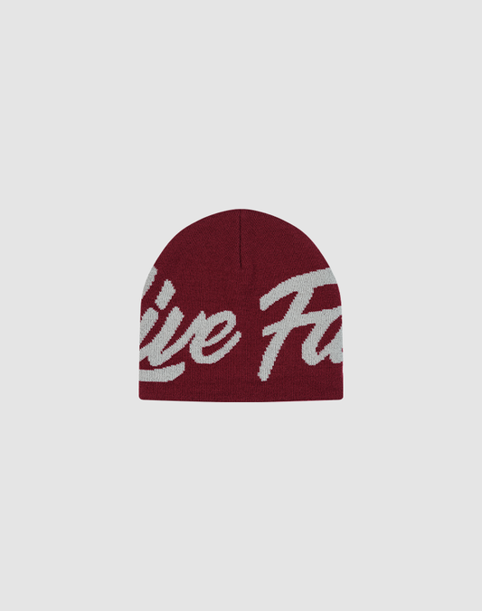 The LFDY Jacquard Beanie by LIVE FAST DIE YOUNG is a maroon polyamide knit hat with bold white Logo Strick script lettering across the front, shown on a plain light gray background.