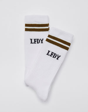 Two white Basic Socks (2 Pack) by LIVE FAST DIE YOUNG, made from soft Baumwolle and elastan, feature two brown stripes near the top and black LFDY text below. They are shown overlapping on a plain white background.