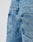 Close-up of the back of a person wearing LFDY Baggy Denim by LIVE FAST DIE YOUNG in light blue, featuring a baggy fit with wide straight legs, two back pockets, and a small black fabric tag on the right pocket.