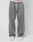 A person wears the LIVE FAST DIE YOUNG Basic Wide Jogger—oversized fit gray sweatpants with white drawstrings and white sneakers, standing against a plain light background. The waistband showcases the LIVE FAST logo for a bold accent.
