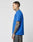 A tattooed man stands in profile against a white background wearing the LIVE FAST DIE YOUNG LFDY Crash Kid Tee in blue and dark regular fit jeans, with visible topstitching on the shirt.