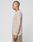 A person with a shaved head and tattoos stands in profile, wearing the beige LIVE FAST DIE YOUNG Basic Regular Rib Longsleeve and light-colored soft cotton pants, set against a plain white background.