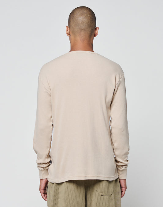 A person with a shaved head stands facing away, wearing the LIVE FAST DIE YOUNG Basic Regular Rib Longsleeve and light brown Regular Fit pants against a plain white background.