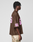 A person in profile wears the LIVE FAST DIE YOUNG LFDY Mesh Jersey—an oversized brown mesh top with a V-neck and pink 55 on sleeve and back—paired with camo pants, set against a plain light gray background.
