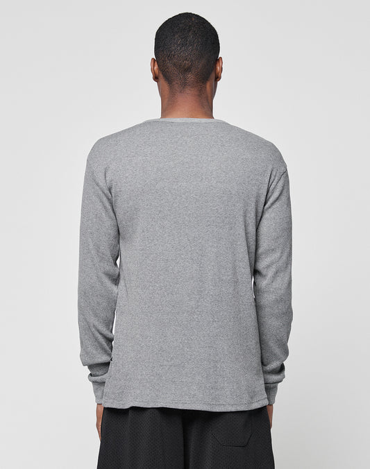 A person faces away from the camera, dressed in a gray Basic Regular Rib Longsleeve by LIVE FAST DIE YOUNG and black shorts, set against a plain light gray background.