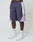 A person wearing LIVE FAST DIE YOUNG Basic Nylon Trackshorts in purple, white sports socks with LFDY text, and white sneakers stands against a plain white background. Only the lower body is visible.