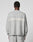 A person faces away in a light gray, oversize Live Fast Boucle Sweater by LIVE FAST DIE YOUNG, featuring “LIVE FAST” in white on the back. Made from 100% polyester and paired with matching gray pants.