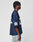 A person with short curly hair stands in profile against a plain light background, wearing the LIVE FAST DIE YOUNG LFDY Mesh Jersey in navy blue with white numbers and an oversized fit V-neck, paired with light blue jeans.