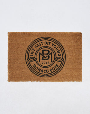 Die Monaco Boys Doormat von LIVE FAST DIE YOUNG ist eine braune Kokosfaser-Fußmatte mit schwarzem kreisförmigem Design und eignet sich ideal für drinnen und draußen auf schlichtem weißen Hintergrund.| plain 