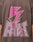 A person wears the LFDY Flash Tee by LIVE FAST DIE YOUNG—an oversized brown Cotton-Slub shirt with a large pink lightning bolt and bold LIVE FAST prints front and back, featuring a dynamic cracked effect around the text.