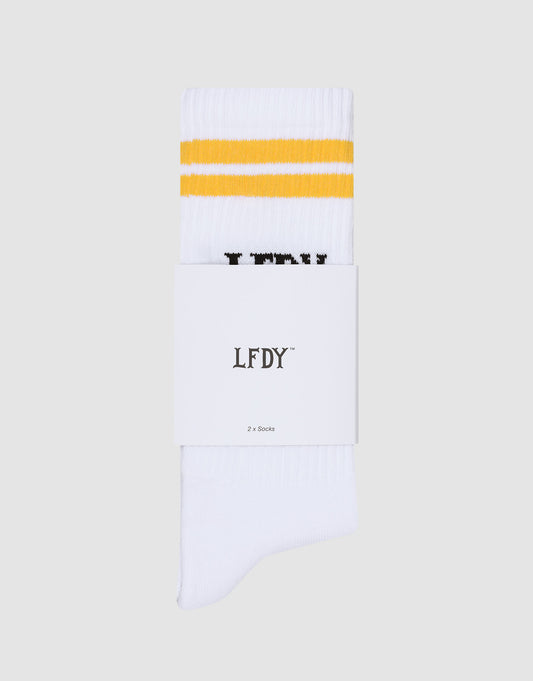 A pair of white LIVE FAST DIE YOUNG LFDY Logo Socks (2 Pack) with two yellow stripes, folded with a label reading "LFDY 2 x Socks," shown on a light gray background. One size and easy-care (pflegeleicht waschen).