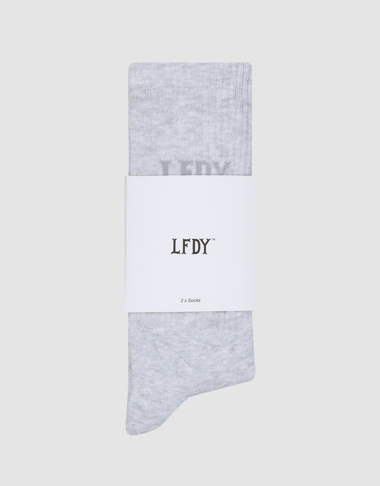 A pair of light grey LFDY Logo Socks (2 Pack) by LIVE FAST DIE YOUNG, folded vertically and wrapped with a white label reading LFDY and 2er Set in black text, displayed on a plain light grey background.