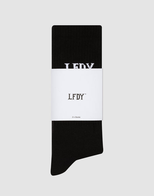 Ein Paar schwarze LFDY Logo Socks (2 Pack) von LIVE FAST DIE YOUNG aus Baumwolle, pflegeleicht waschbar, ordentlich gefaltet mit weißem LFDY-Label und „2 x Socks“-Text. Teil des LFDY Logos ist auf der Socke sichtbar.