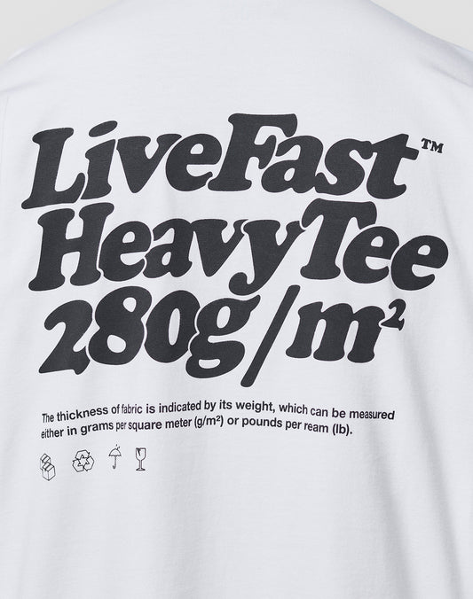 A white Oversize Fit Basic 280 Tee by LIVE FAST DIE YOUNG, with bold black text: Live Fast Heavy Tee 280g/m². Smaller text notes fabric thickness in grams/m² and lbs/ream, plus laundry icons. Made from 100% Baumwolle.