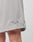 Close-up of a persons leg wearing LIVE FAST DIE YOUNG Basic Mesh Shorts in light gray, 100% polyester, regular fit, with a small diamond-shaped logo patch near the hem.