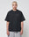 A person with short bleached blond hair wears a loose black LIVE FAST DIE YOUNG Basic 280 Tee with backprint and gray mesh shorts in an oversize fit, standing against a plain white background.