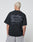 A person with short, light blond hair is seen from behind wearing a black Basic 280 Tee by LIVE FAST DIE YOUNG, featuring an oversize fit and a bold gray backprint reading Live Fast Heavy Tee 280g/m² with additional smaller text.