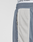 Close-up of a person wearing LFDY DY Trackpants by LIVE FAST DIE YOUNG, featuring blue and beige polyester fabric, a visible zipper pocket, and a white Elastikbund waistband with "LIVE FAST" printed on it.