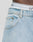 Close-up of a person wearing LFDY Baggy Denim jeans from LIVE FAST DIE YOUNG, with a focus on the pocket and waistband area where white underwear with black stripes and partial black text is visible.