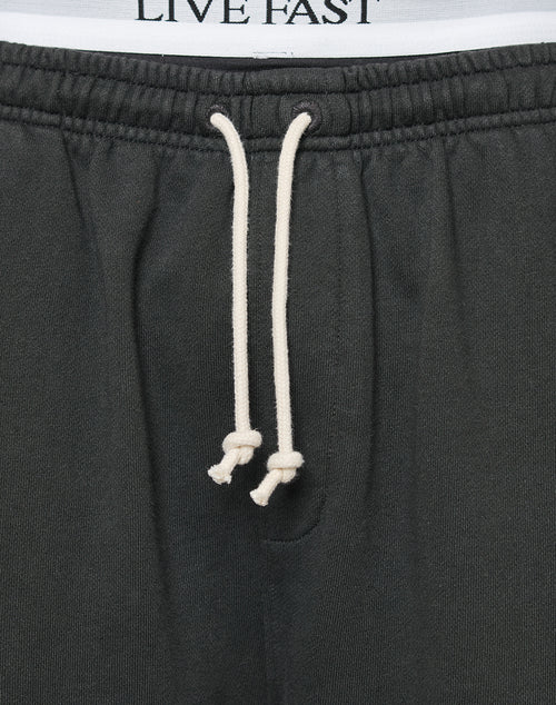 Close-up of the LFDY Lightweight Jogger by LIVE FAST DIE YOUNG—black sweatpants with white knotted drawstrings and LIVE FAST on the inner waistband. Made from soft French Terry fabric for comfort and an oversized fit.