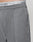 Close-up of a person in Wide Casual Pants by LIVE FAST DIE YOUNG, featuring a straight leg and subtle pleats. The elastic waistband of white underwear with LIVE FAST in black shows above the pants.